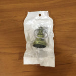 Metal temple bell keychain resting on a textured surface, showcasing its elegant form.